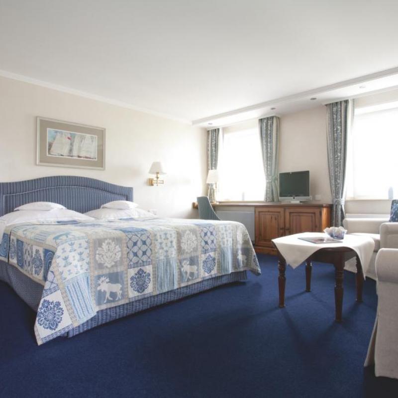 Zimmer 2. Traumhaftes blaues Zimmer mit großem Doppelbett, grauen traditionellen Sesseln und schöner Beleuchtung