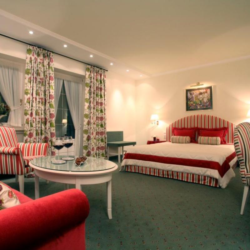 Zimmer 15: großes Zimmer mit King sized Bed, Sessel, Sofa und Stuhl sowie farblich abgepassten Dekoschaals