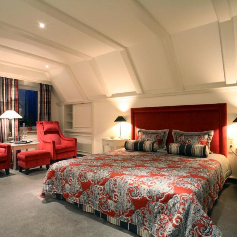 Zimmer 37: Große Suite mit bequemen Doppelbett, zwei roten Sesseln und tollem Ausblick über das Sauerland