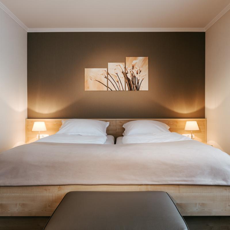 Zimmer 41: gemütliches Doppelbett mit Schmuckvollen Wandbildern